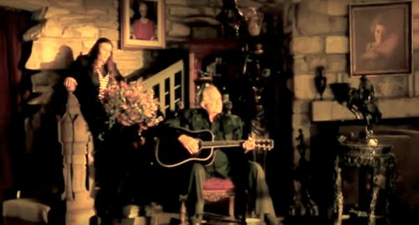 Johnny and June sitting near the fireplace and now destroyed wooden staircase.
