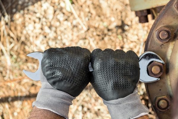 Hands with Work Gloves Holding a Wrench and Tighten very Rusty Bolts