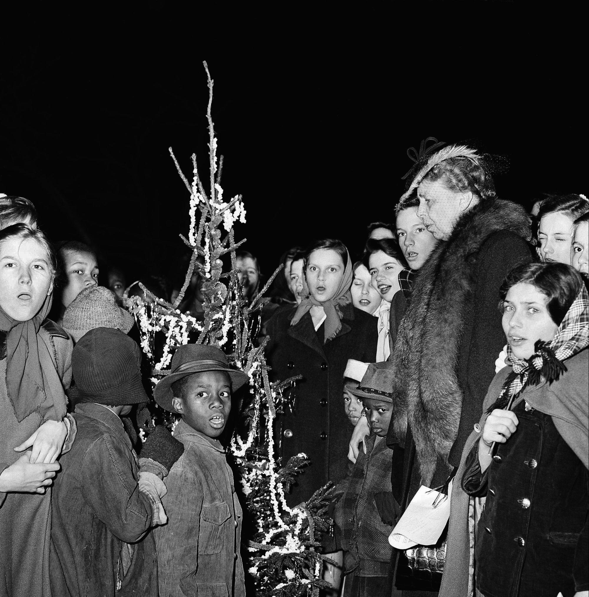 Mrs. Franklin D. Roosevelt (at the right) sings with children in a program of Christmas carols before an outdoor Christmas tree, in Washington, D.C., on Dec. 21, 1944. 