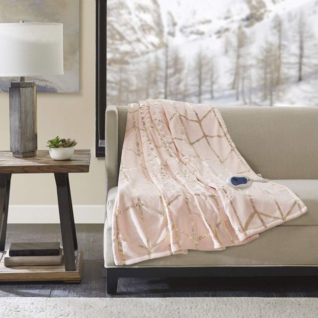 best heated throw blanket in light color pink draped over couch