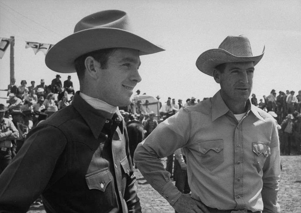 Rodeo champions Bill Linderman (R) and Casey Tibbs watching the rodeo. (Photo by Carl Iwasaki/Getty Images)