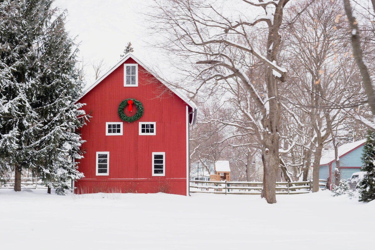 Red barn with Christmas wreath on snowy midwestern day