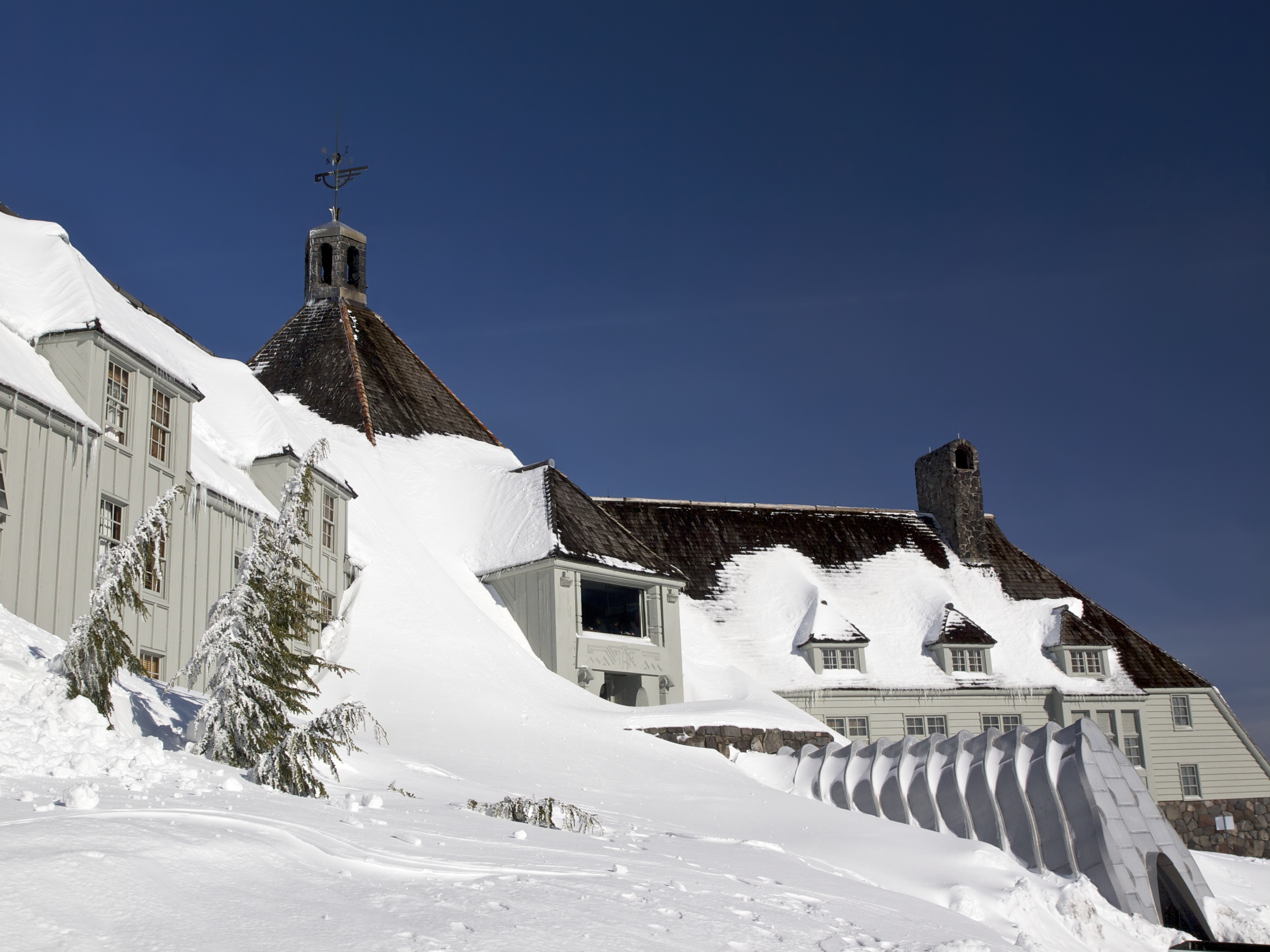 Looking from the side of Timberline Lodge toward the center of building. The entrance area and window to the restaurant are visible. The Lodge is a National Historic Landmark. This is on Mt Hood located in Northwest Oregon.