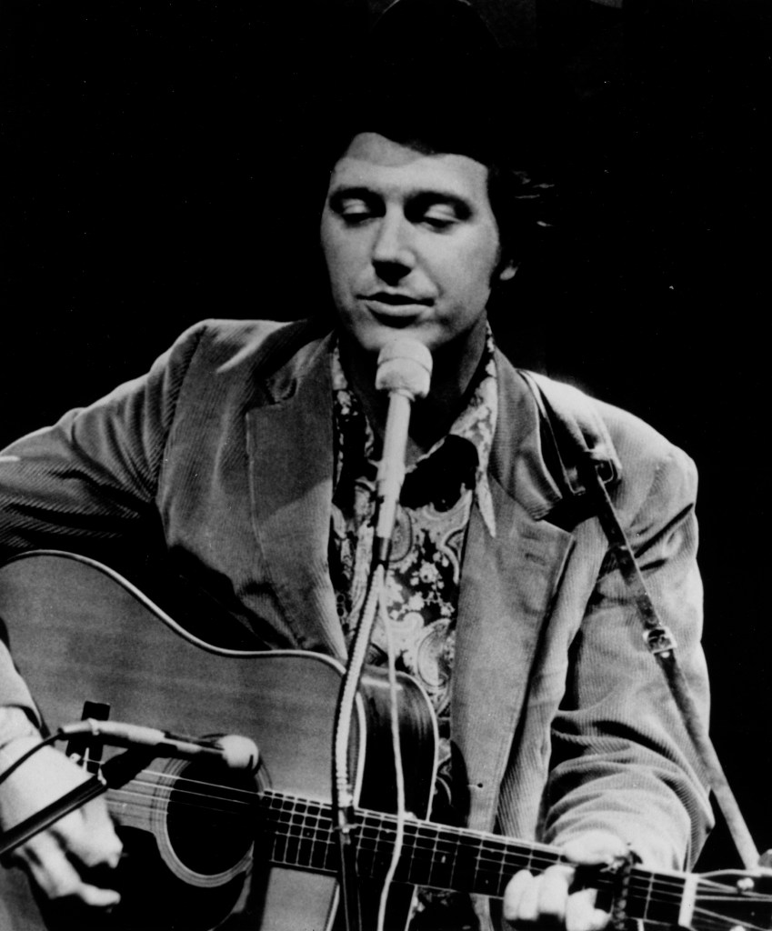 Jerry Jeff Walker performing onstage with an acoustic guitar in circa 1971