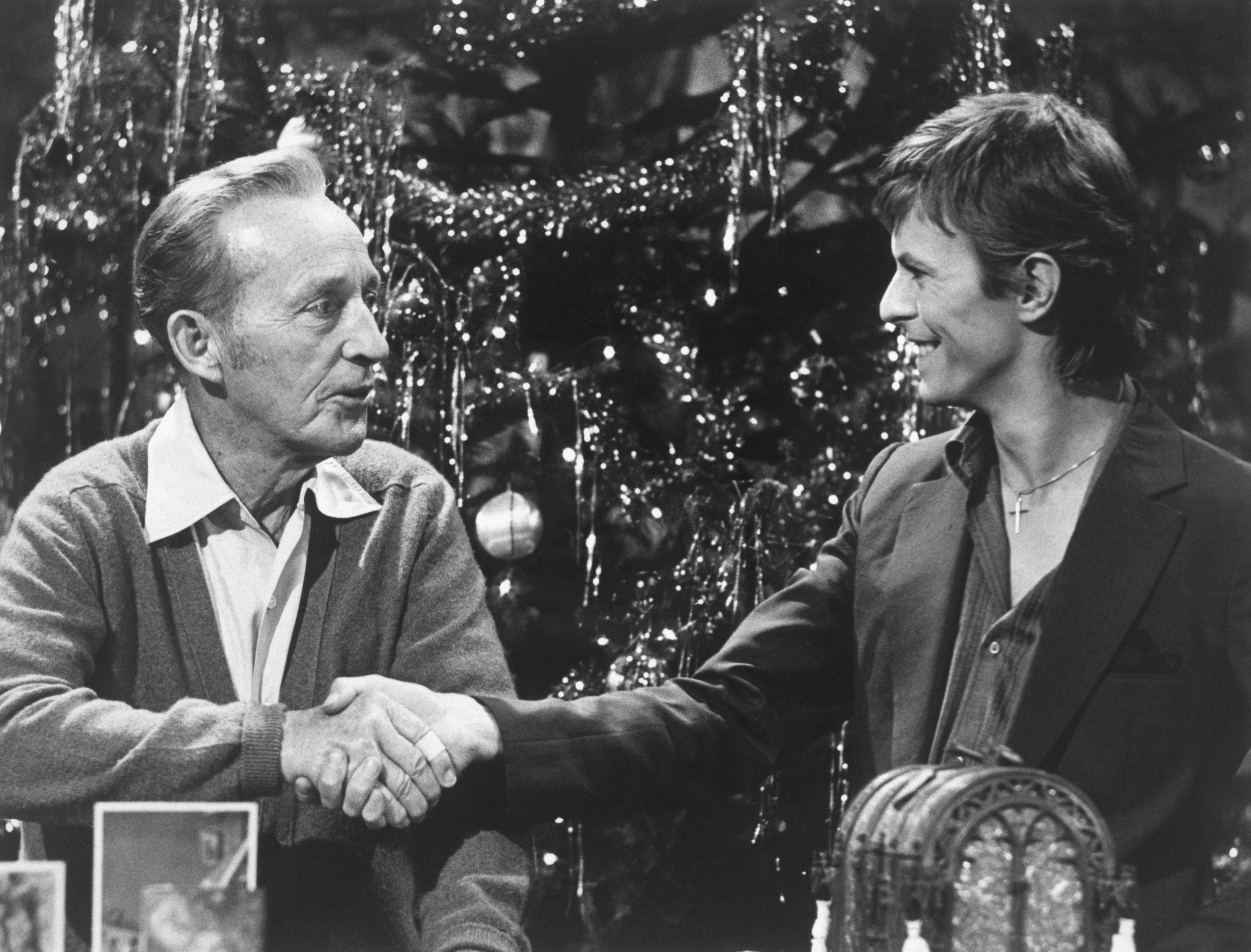 Bing Crosby and David Bowie shake hands during the taping of the television special "Bing Crosby's Merrie Olde Christmas". The two singers, of diverse styles, sang together on "Little Drummer Boy."