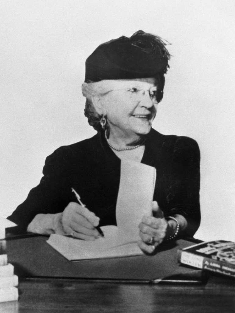 Picture shows author Laura Ingalls Wilder, of the "Little House" books, autographing a book