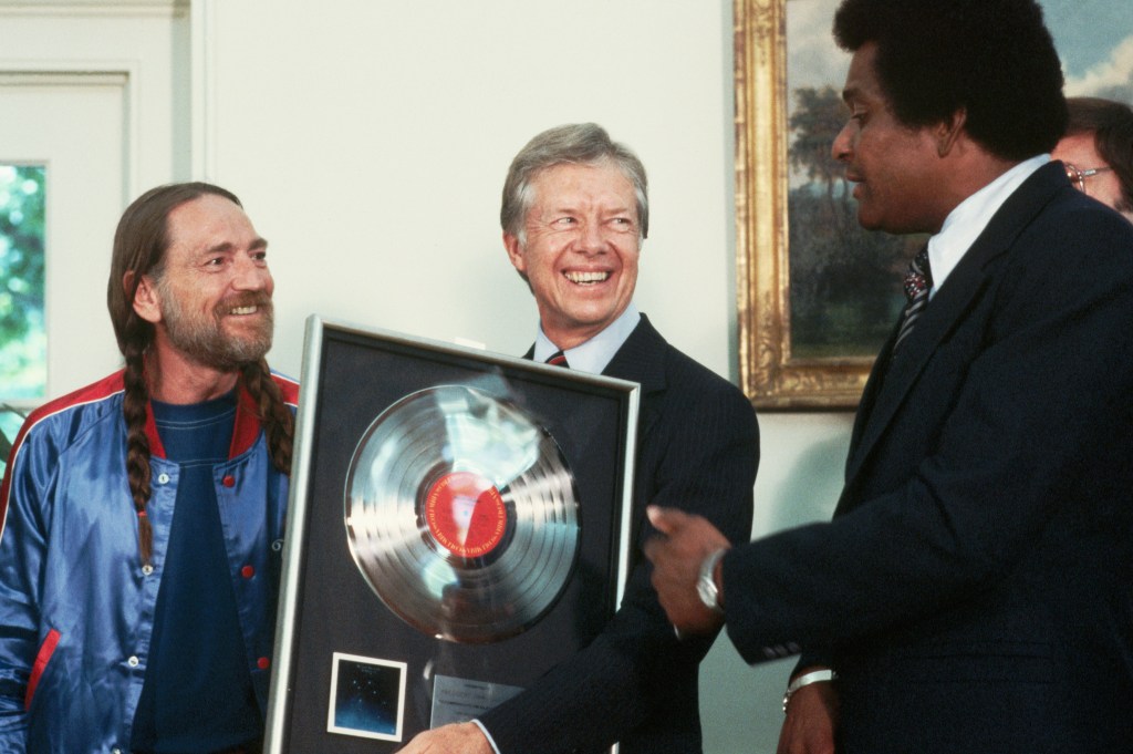 Country singers Willie Nelson and Charley Pride present a gold record to President Jimmy Carter at the Oval Office. (Photo by &copy; Wally McNamee/CORBIS/Corbis via Getty Images)