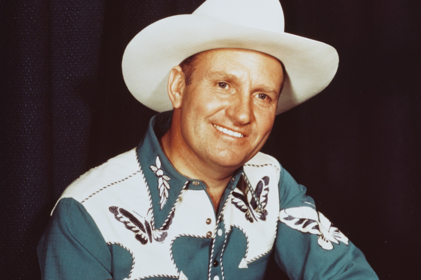 US singer and actor, wearing a white cowboy hat and blue-and-white shirt with butterfly motifs in a studio portrait, against a black background, USA, circa 1950. Autry gained fame as 'The Singing Cowboy' on radio, in the movies and on television.