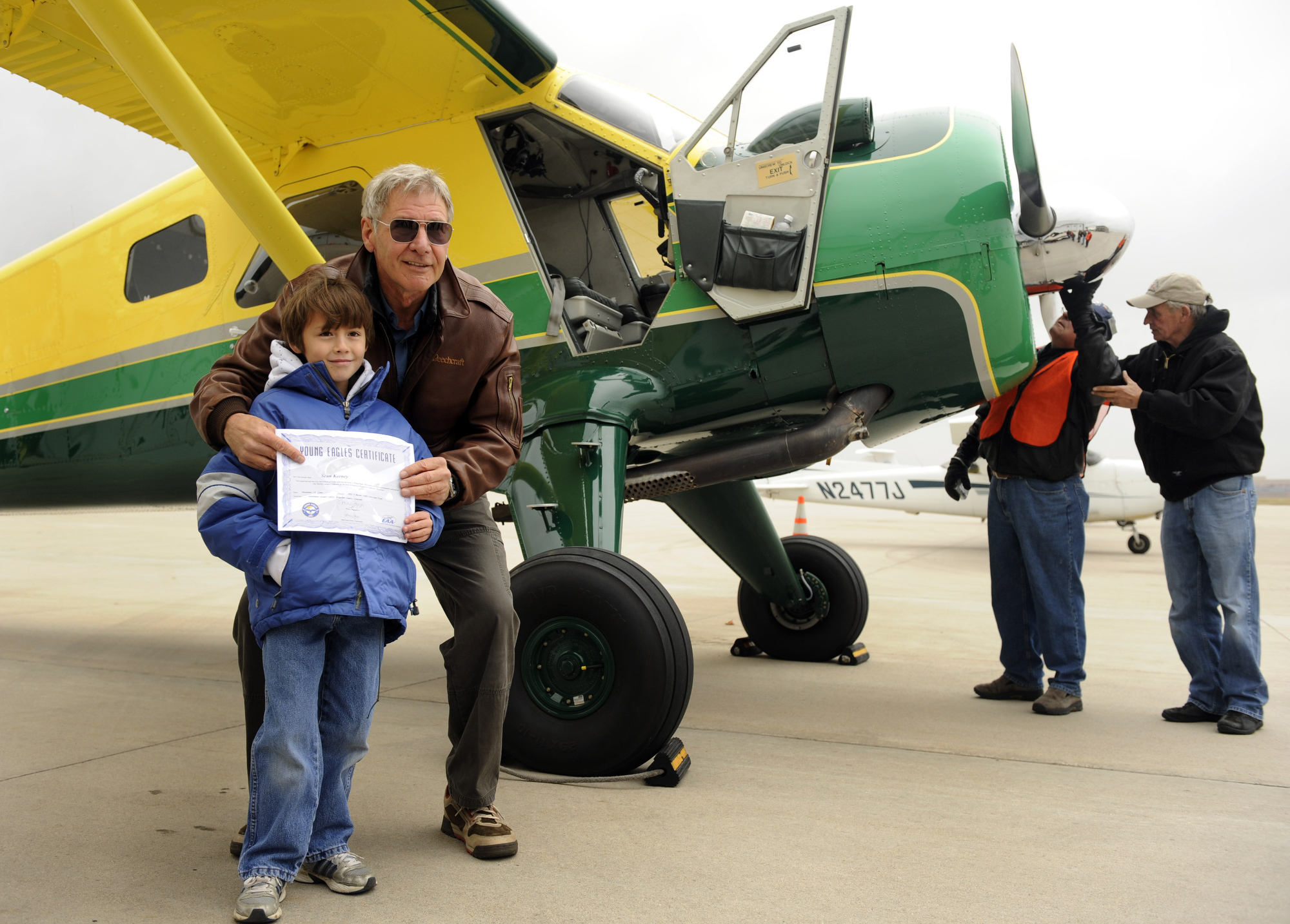 Actor Harrison Ford visits Denver and gives some kids an airplane ride from Centennial Airport. Sean Keeney, 8, of Littleton gets his photo taken with Ford after his plane ride. For Bill Husted column. Kathryn Scott Osler, The Denver Post 