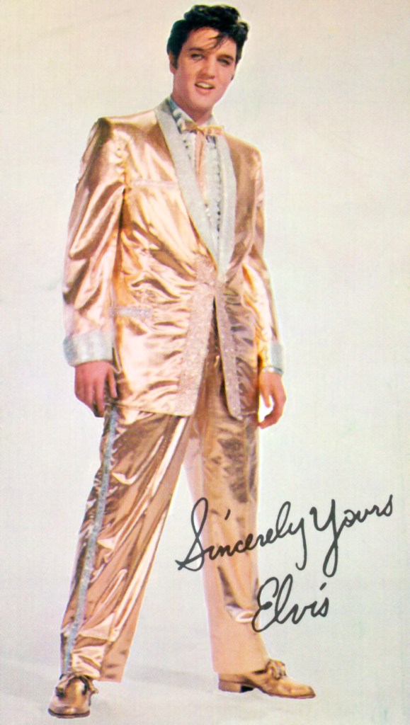 1957: Rock and roll musician Elvis Presley poses with clothes designer Nudie Cohen in his $2500 gold-leaf suit. He only wore the full suit twice on stage. On March 28, 1957 he wore it at the Saddle and Sirloin Club at the Stockyards Inn in Chicago. He also wore it March 29, 1957 at Kiel Auditorium in St. Louis, Missouri.
