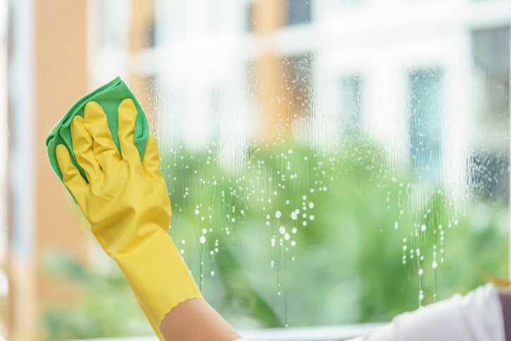 cleaning the mirror with green cloth.