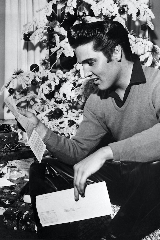(Original Caption) 12/20/1957-Memphis, TN: Rock 'n' roll crooner Elvis Presley reads an unexpected "greeting" -- a notice to report to military induction on January 20th. The idol of the teenagers is scheduled to begin making a film on the same day, however, so a studio official says that he will ask for a temporary postponement of Presley's induction. If Presley is not available for the movie, the studio and the producer will possibly lose between $300,000 and $350,000.