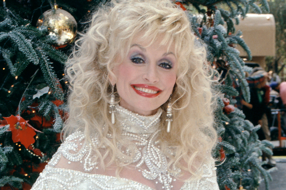 American singer-songwriter Dolly Parton poses for a portrait in front of a Christmas Tree circa 1992 in Lake Tahoe, California.