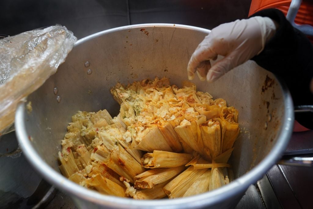 A street vendor sells tamales