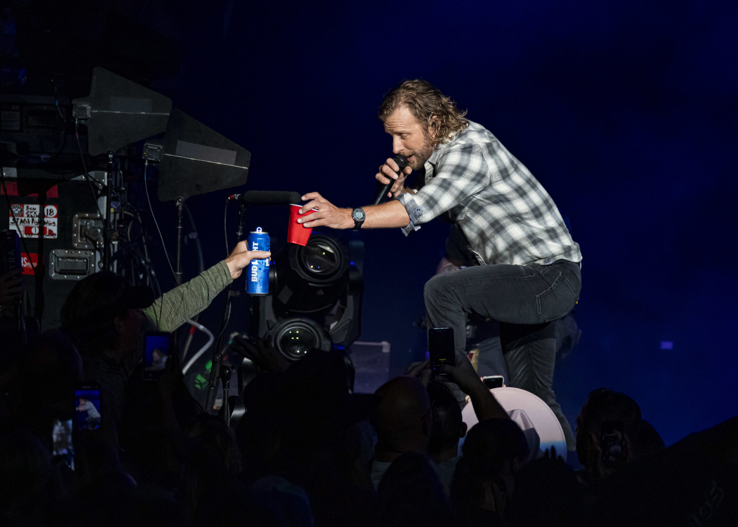 Dierks Bentley toasts an audience member during a live performance.