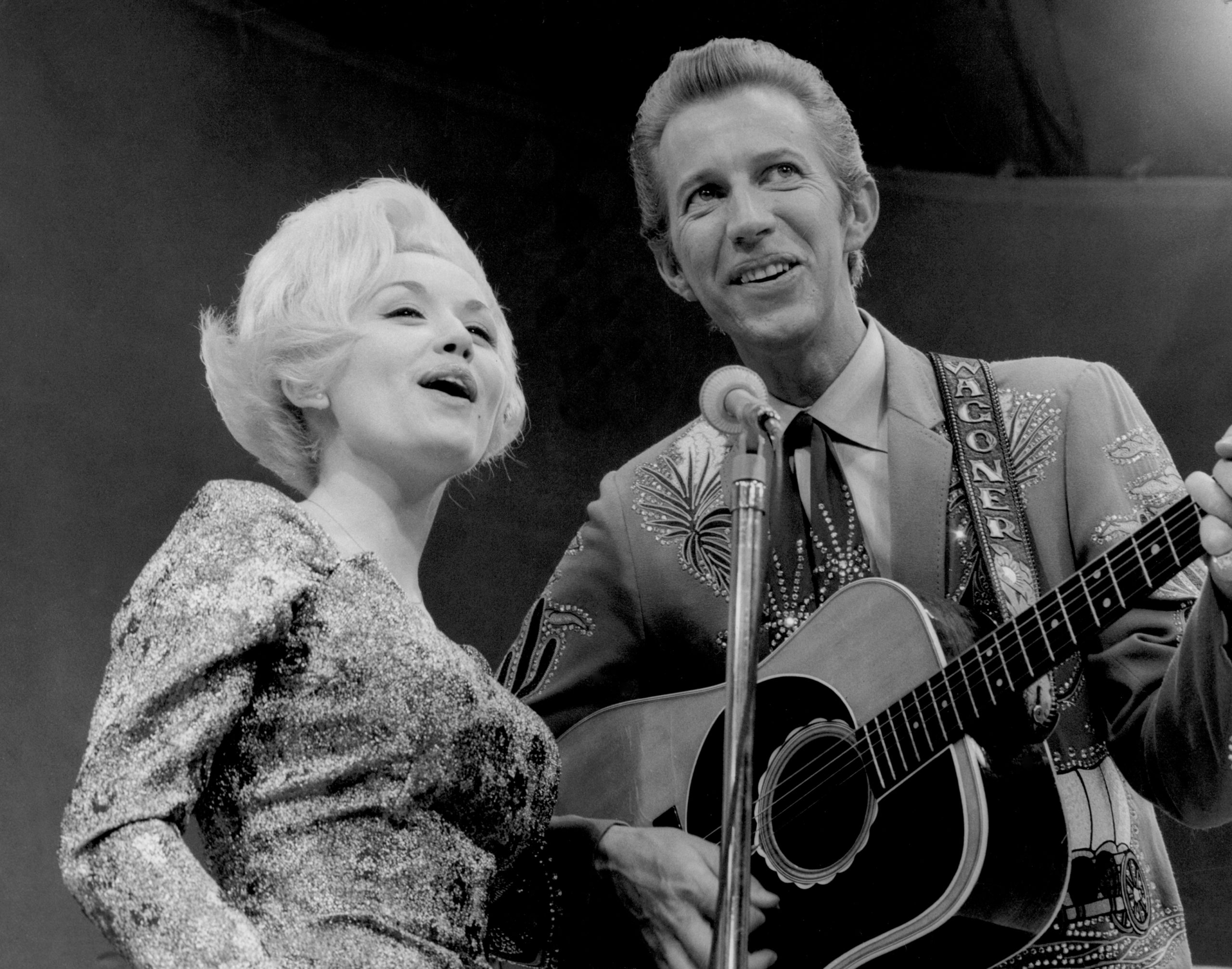 Country singers Dolly Parton and Porter Wagoner perform onstage in circa 1967 in Nashville, TN. Mr. Wagoner is wearing a Nudie suit desgned by Nudie Cohn of Nudie's Rodeo Tailors.