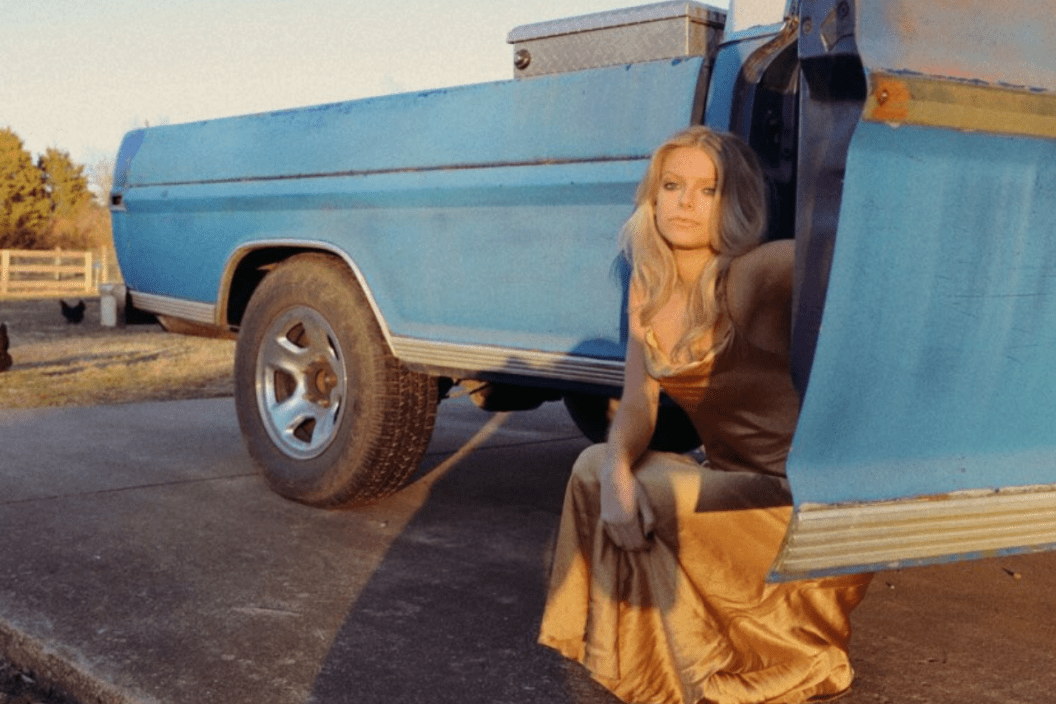 Carter Faith poses beside a pickup truck