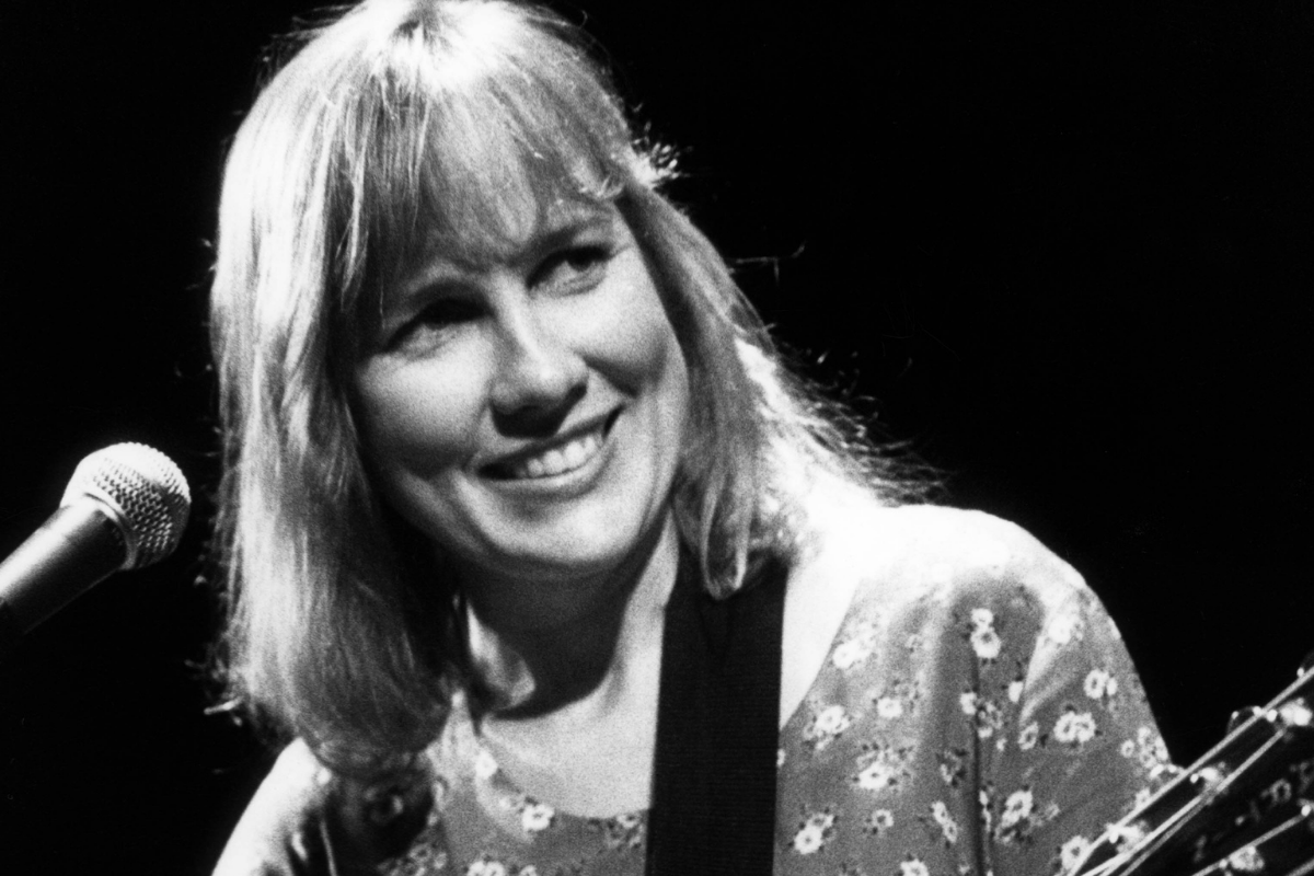 black and white photo of Iris DeMent performing onstage