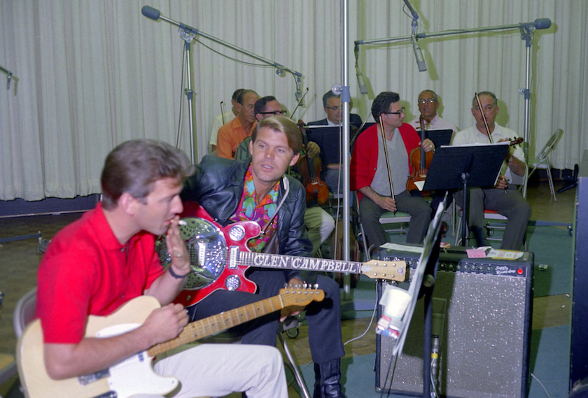 Singer and Songwriter Glen Campbell (R) and guitarist James Burton (L) record at the Columbia Records Studio on September 15, 1967 in Los Angeles, California. 