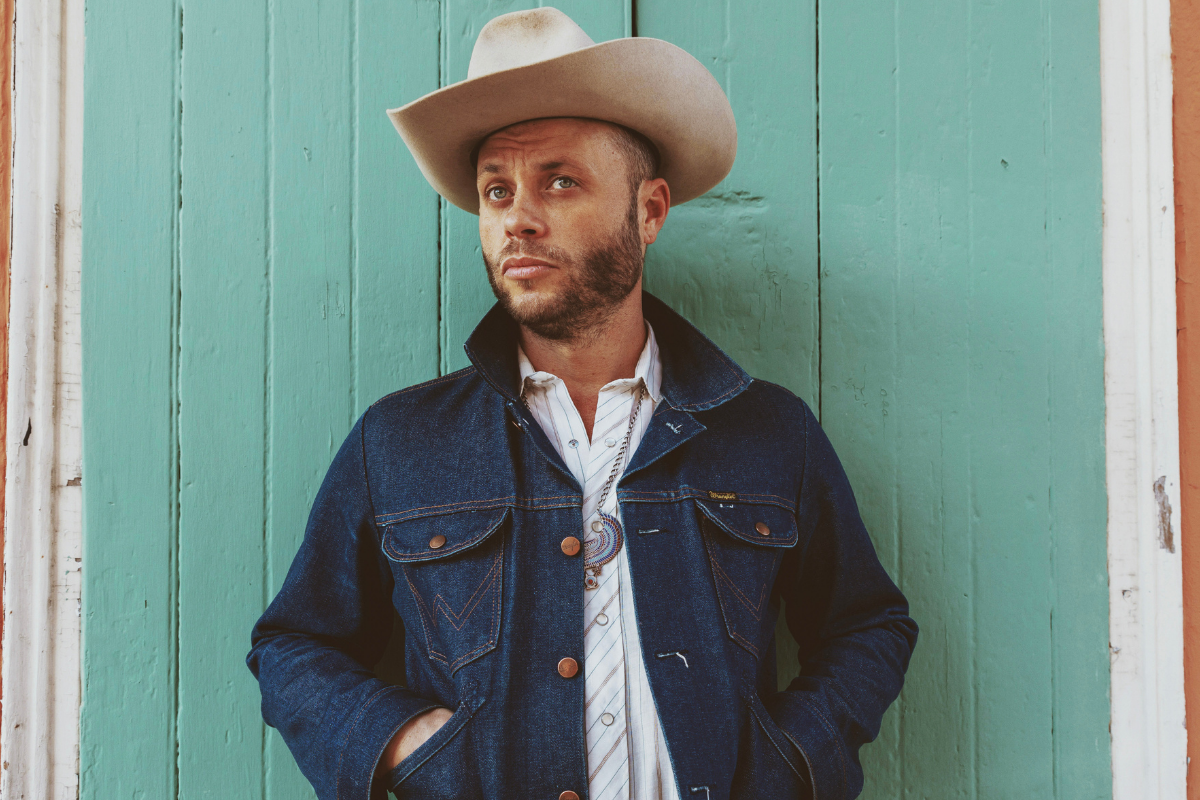 Charley Crockett poses in front of wall