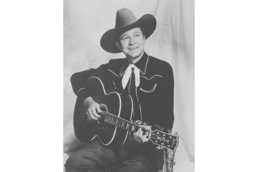 Tex Ritter (1905-1974), American country music singer and movie actor, posing with cowboy hat and guitar, circa 1938