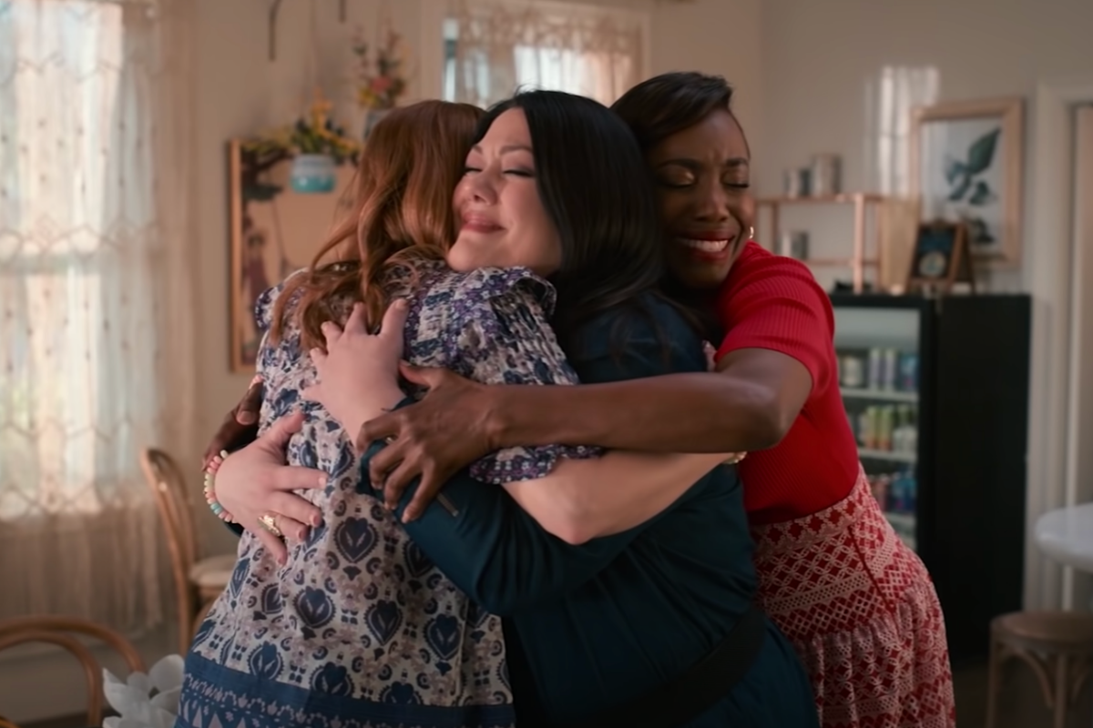 Maddie Townsend (Joanna Garcia Swisher), chef and restaurant owner Dana Sue Sullivan (Brooke Elliott) and lawyer Helen Decatur (Heather Headley) hugging in scene from 'Sweet Magnolias'