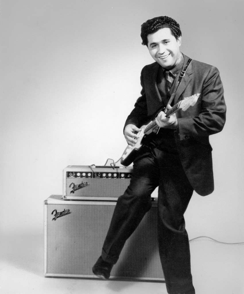 Tex-Mex singer/songwriter Freddy Fender poses for a portrait holding his Fender Stratocaster electric guitar standing next to his Fender amplifiers in circa 1959.