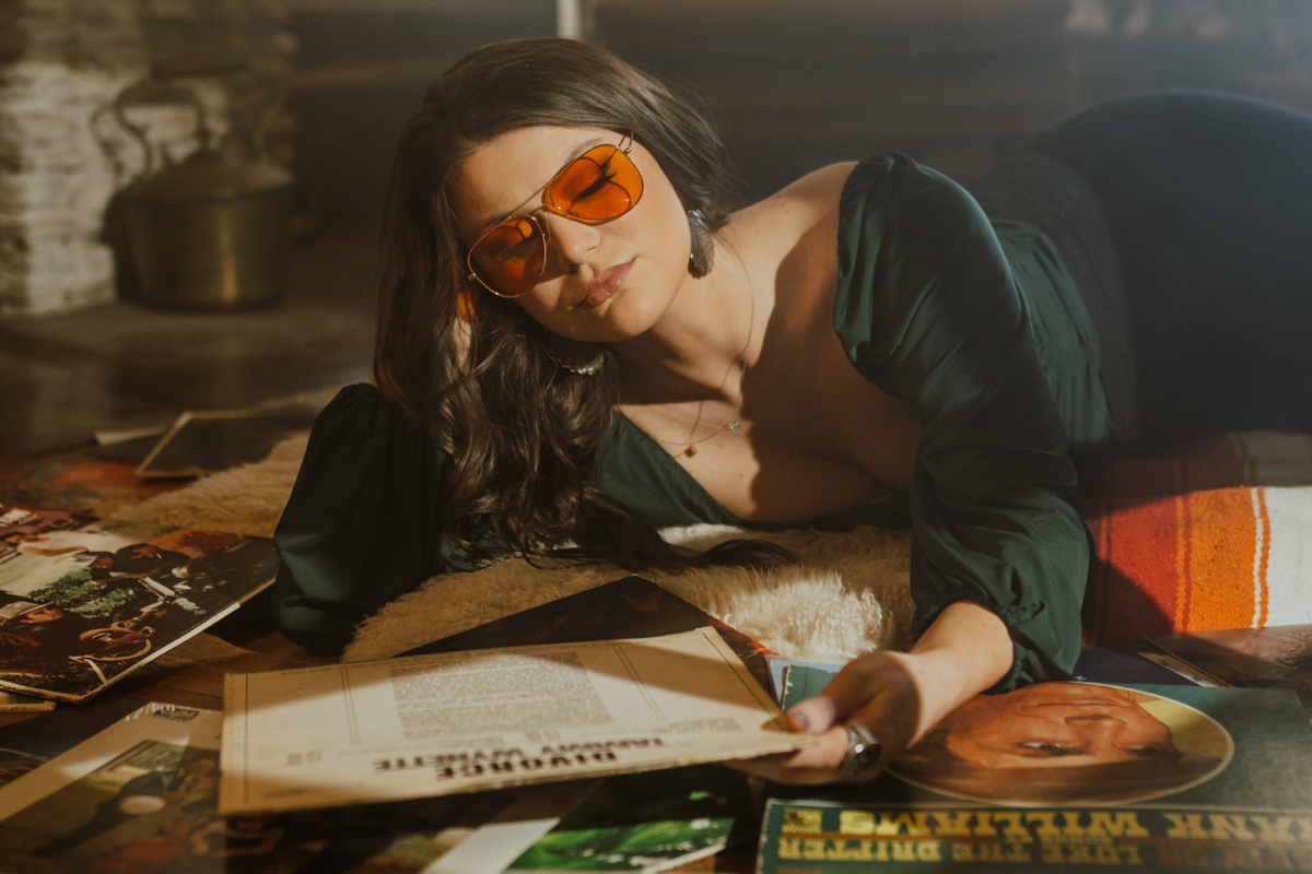 Mae Estes poses looking at vinyl records