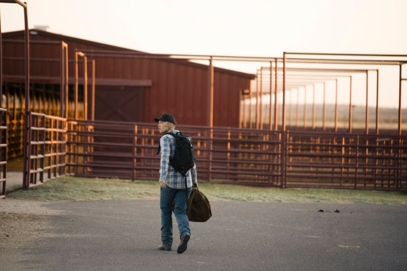 Jimmy carrying a bag walking around the 6666 Ranch in Texas