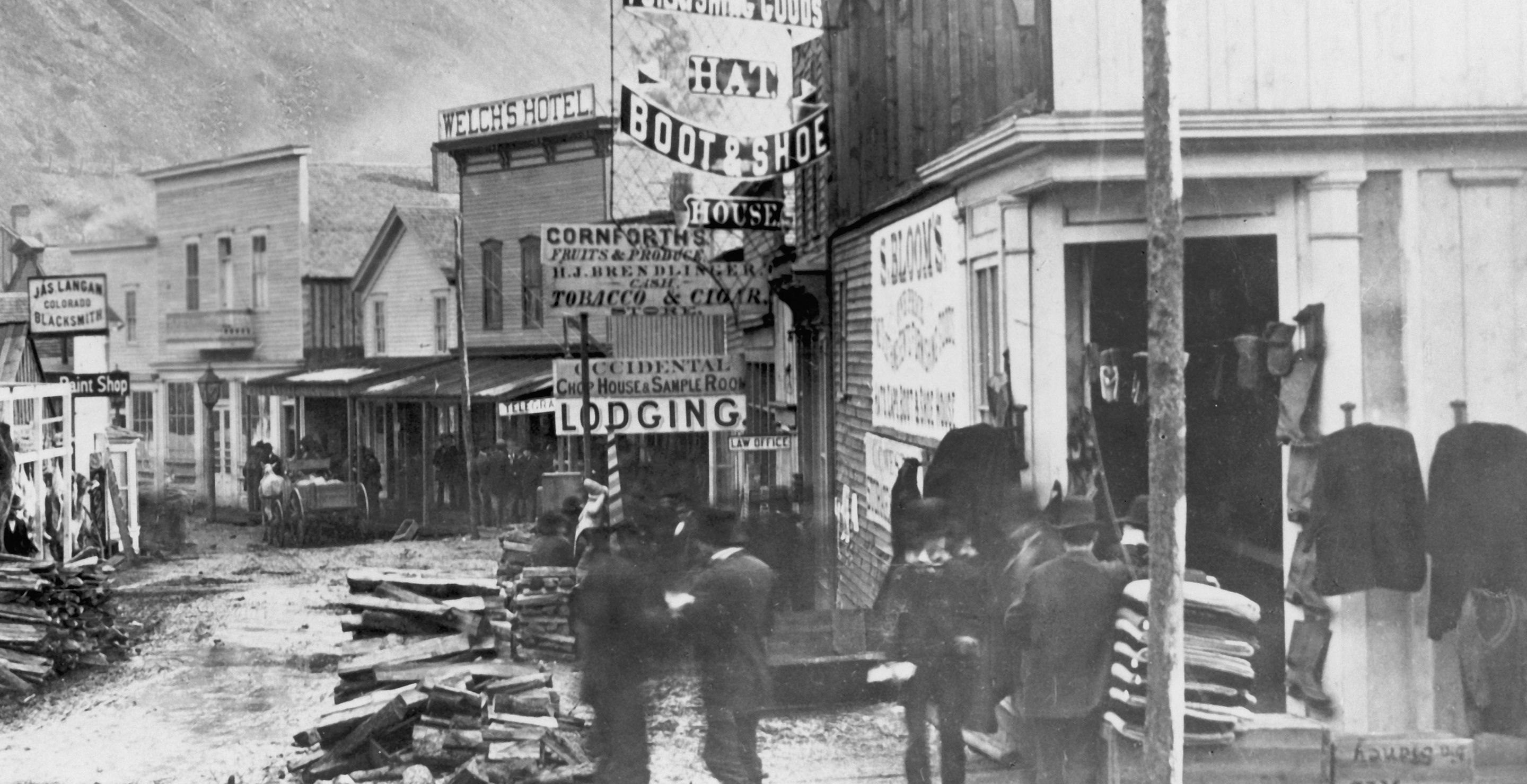View of Deadwood, in South Dakota, in its heyday, as photographed by F.J. Haynes, showing store fronts and a group of men in Deadwood, South Dakota, USA, circa 1877. (
