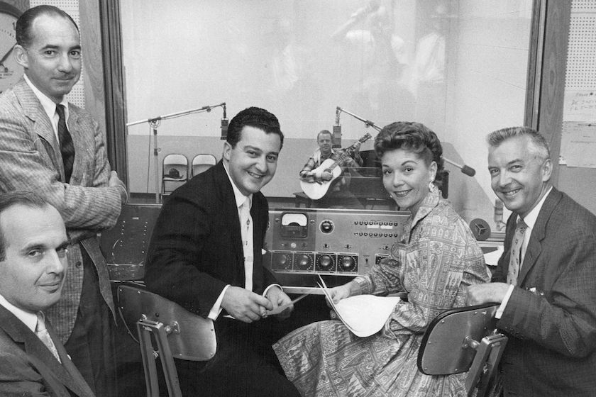 JUL 20 1956, JUL 22 1956 AUDITION CREW&mdash; Gathered in a KLZ sound booth Friday to audition local entertainers for a place on Monday night's "Arthur Godfrey's Talent Scouts" show from Cheyenne were members of the Godfrey gang from New York. They are (left to right) Burt Farber, conductor; Fred Hendrickson, "Scout" selector; Frank Musiello, producer; Janette Davis, vocalist, and Mark Russell, head talent hunter. In the background is Bob Bruso of Denver, western balladeer, first to audition. Credit: Denver Post 