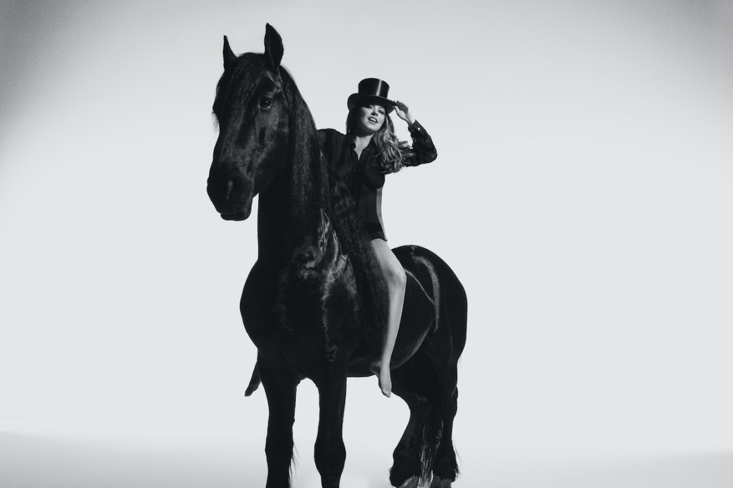 A press shot of Shania Twain for her 2023 album 'Queen of Me.' It shows Twain on a black horse.