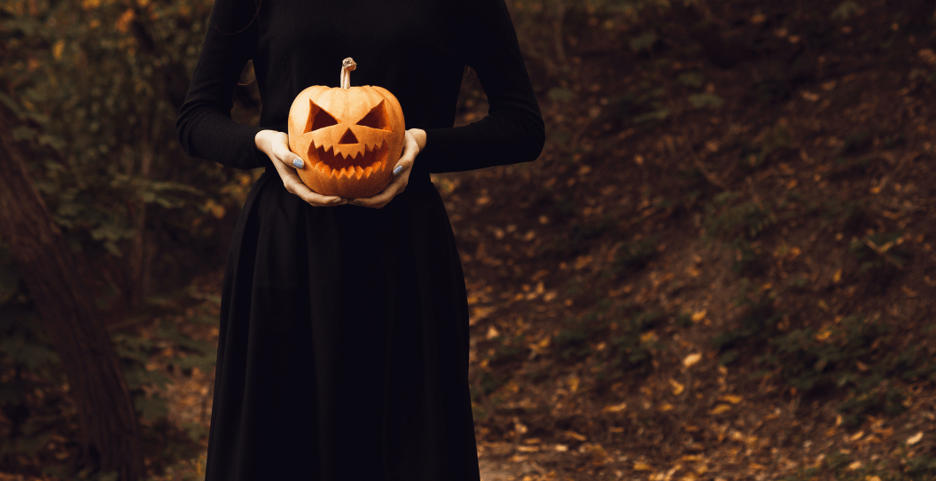 The skinny girl in the guise of a witch holds a lantern jack