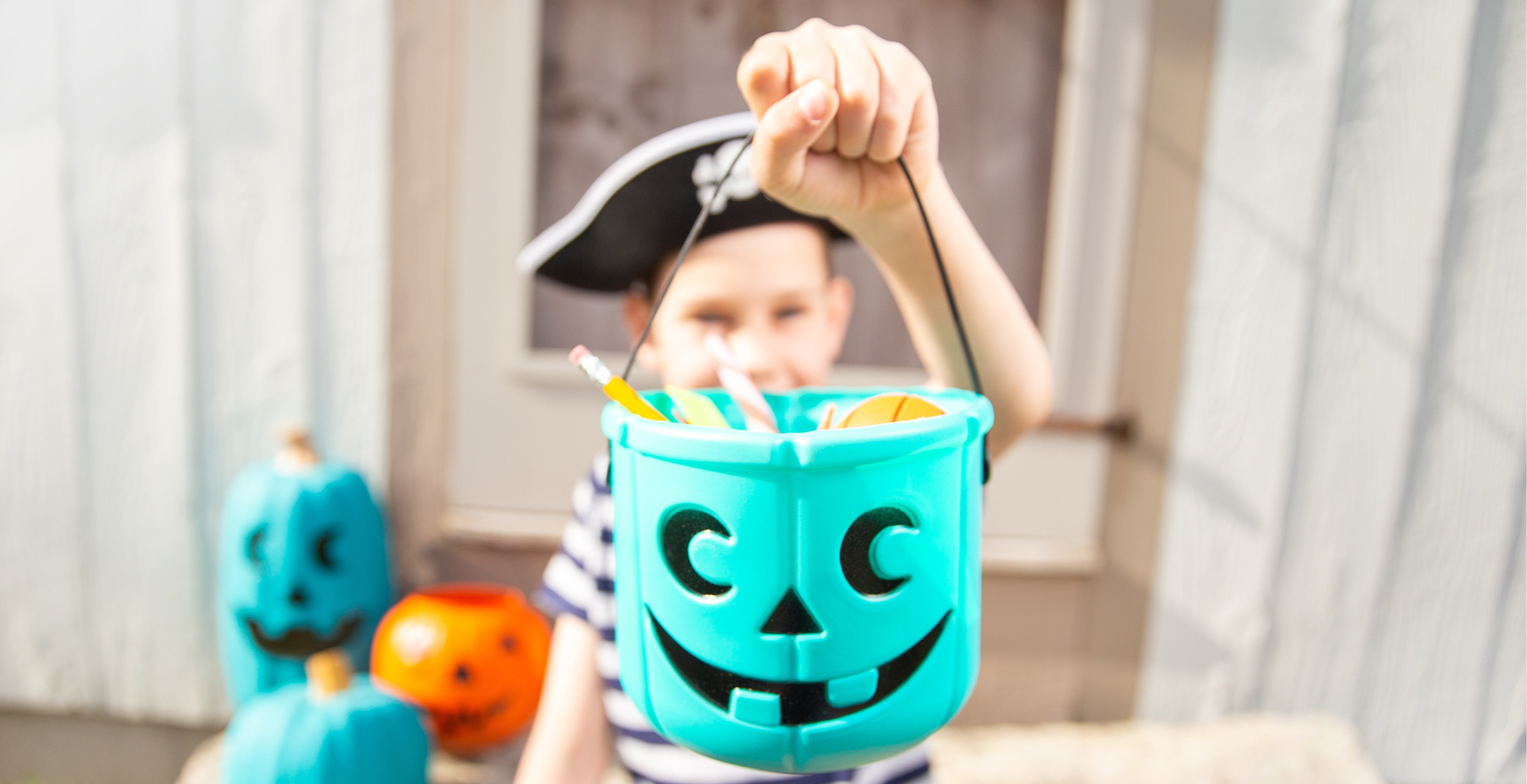 Child holding teal pumpkin