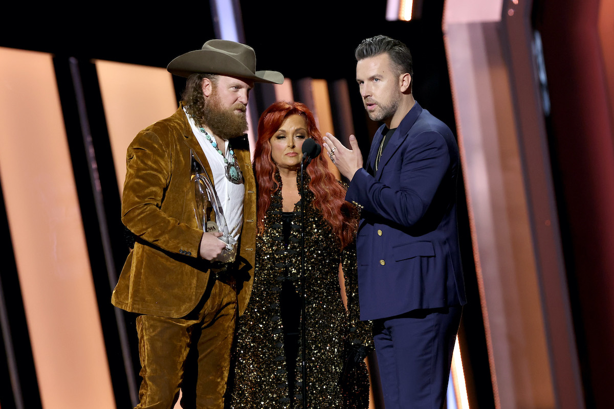 NASHVILLE, TENNESSEE - NOVEMBER 09: John Osborne, Wynonna Judd and T.J. Osborne speak onstage at The 56th Annual CMA Awards at Bridgestone Arena on November 09, 2022 in Nashville, Tennessee.