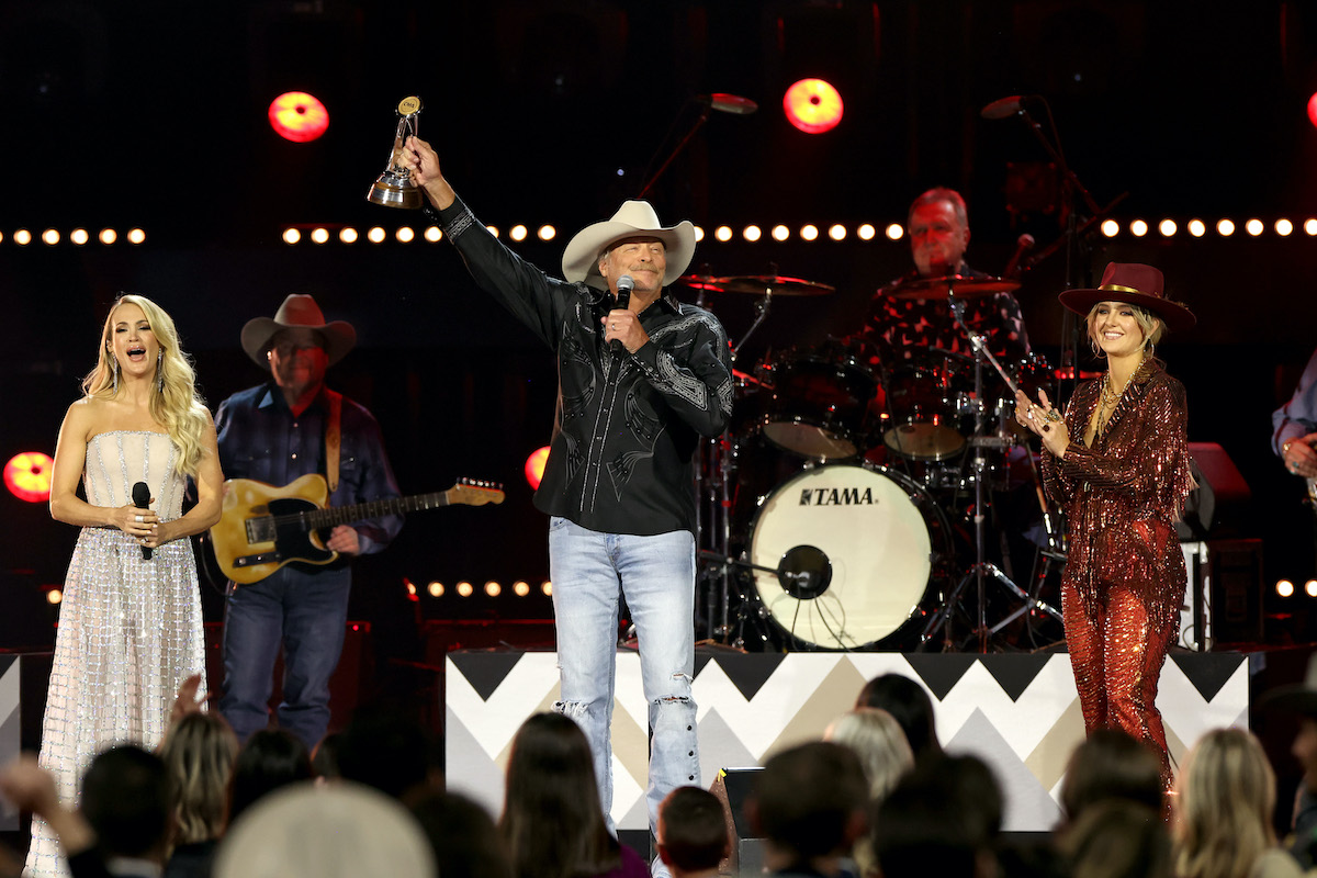 NASHVILLE, TENNESSEE - NOVEMBER 09: (L-R) Carrie Underwood, Alan Jackson, recipient of the Willie Nelson Lifetime Achievement Award, and Lainey Wilson speak onstage at The 56th Annual CMA Awards at Bridgestone Arena on November 09, 2022 in Nashville, Tennessee.
