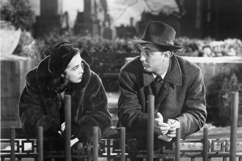 Janet Leigh leaning on gate talking to actor Robert Mitchum in a scene from the film 'Holiday Affair', 1949