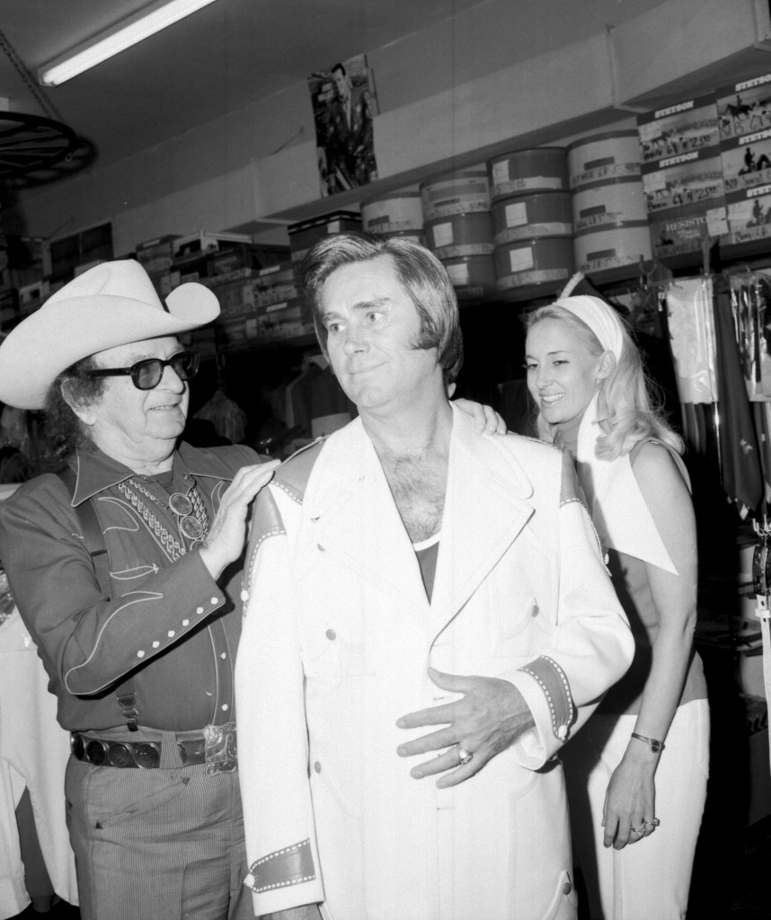 UNITED STATES - MAY 26: May 26, 1973, California, Los Angeles (North Hollywood), George Jones, L-R: celebrity tailor Nudie Cohen and country singers George Jones and Tammy Wynette at Nudies Rodeo Tailors on May 26, 1973 in North Hollywood, Los Angeles, California. 