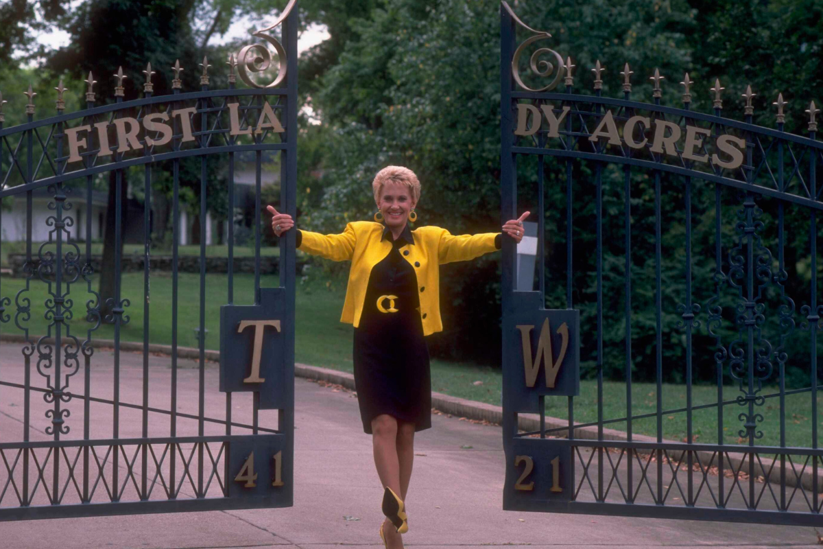 American country music singer and musician Tammy Wynette photographed by the gates of her 'First Lady Acres' home in Nashville, Tennessee, circa 1987.