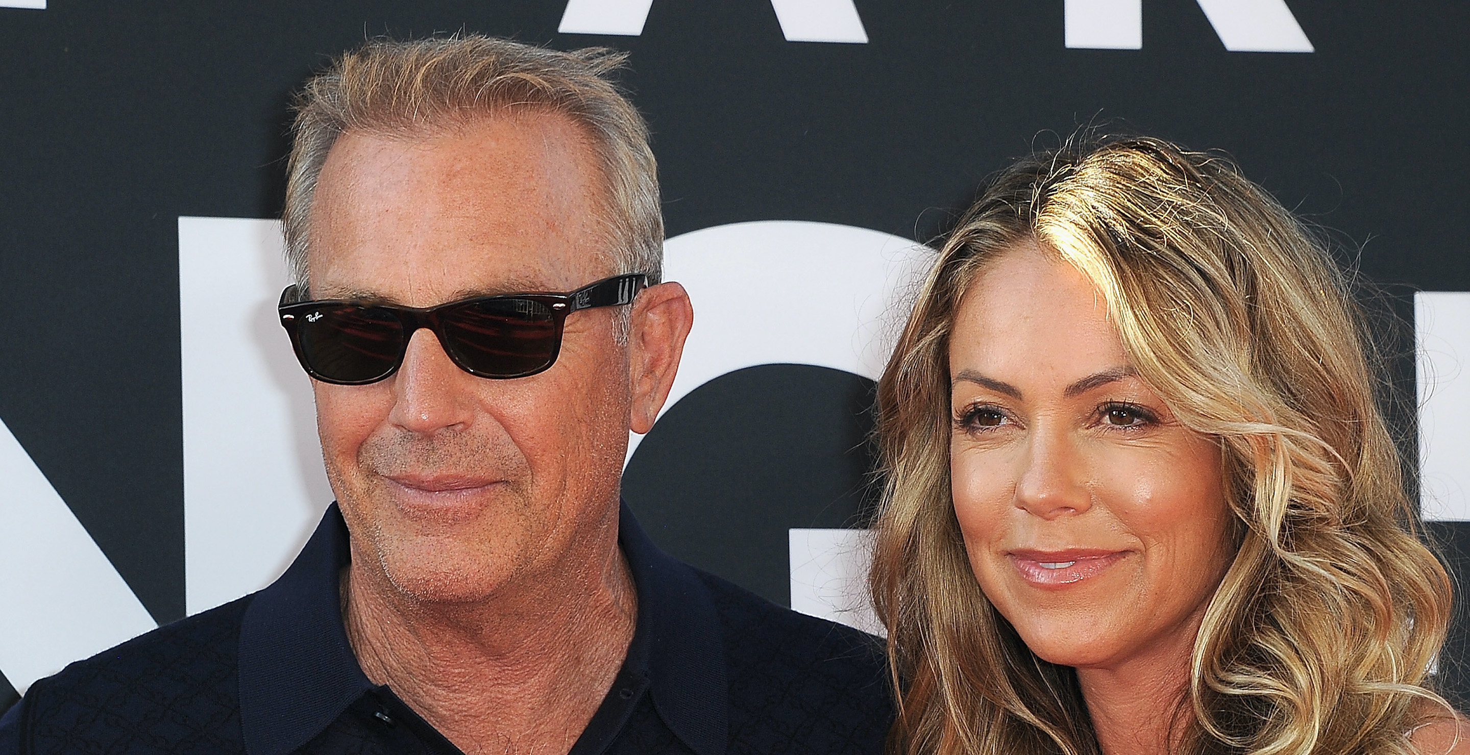LOS ANGELES, CA - AUGUST 01: Kevin Costner and wife Christine Baumgartner arrive for the Premiere Of 20th Century Fox's "The Art Of Racing In The Rain" held at El Capitan Theatre on August 1, 2019 in Los Angeles, California.