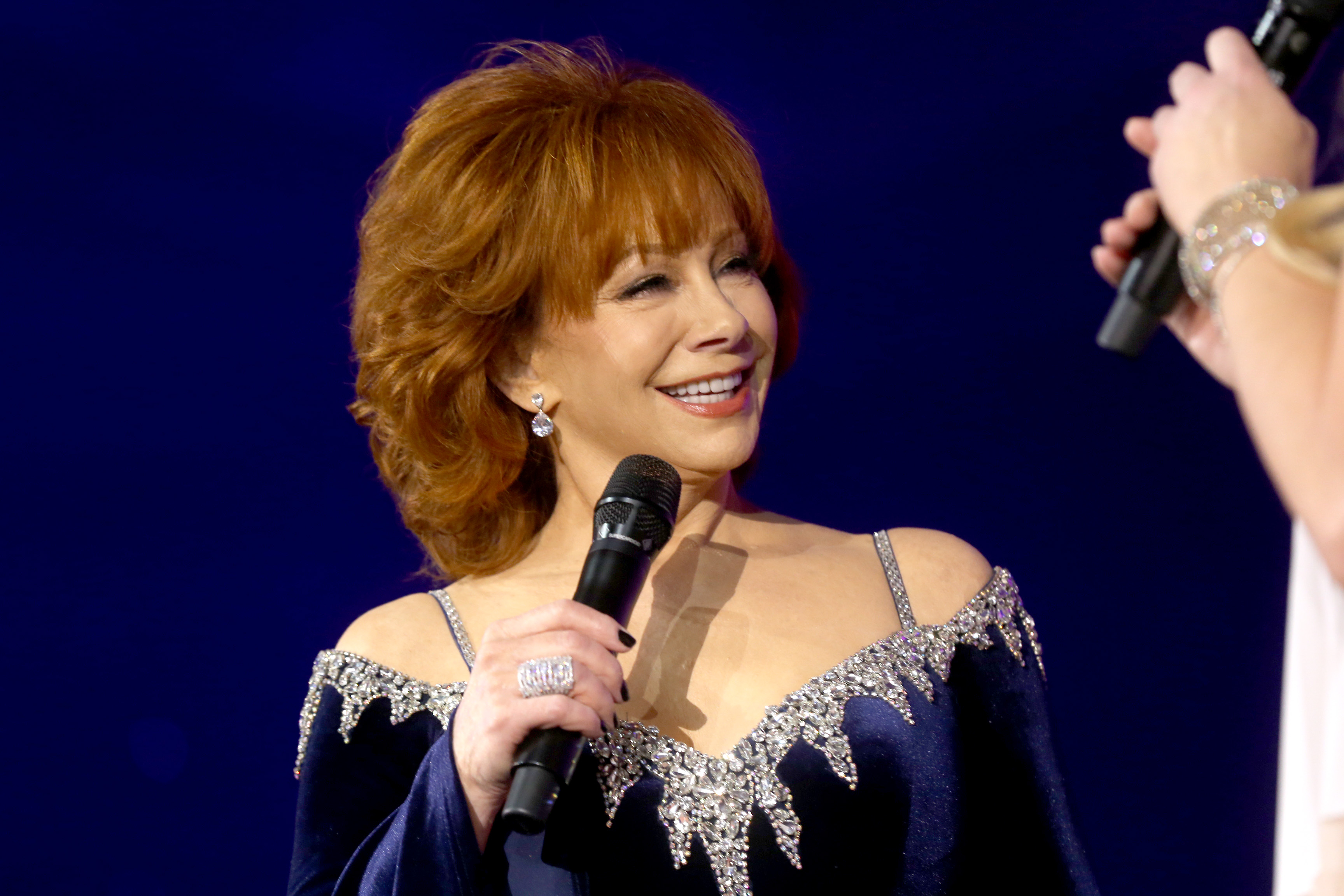 PHOENIX, ARIZONA - MARCH 12: Reba McEntire speaks onstage during Inaugural Gateway Celebrity Fight Night on March 12, 2022 in Phoenix, Arizona.