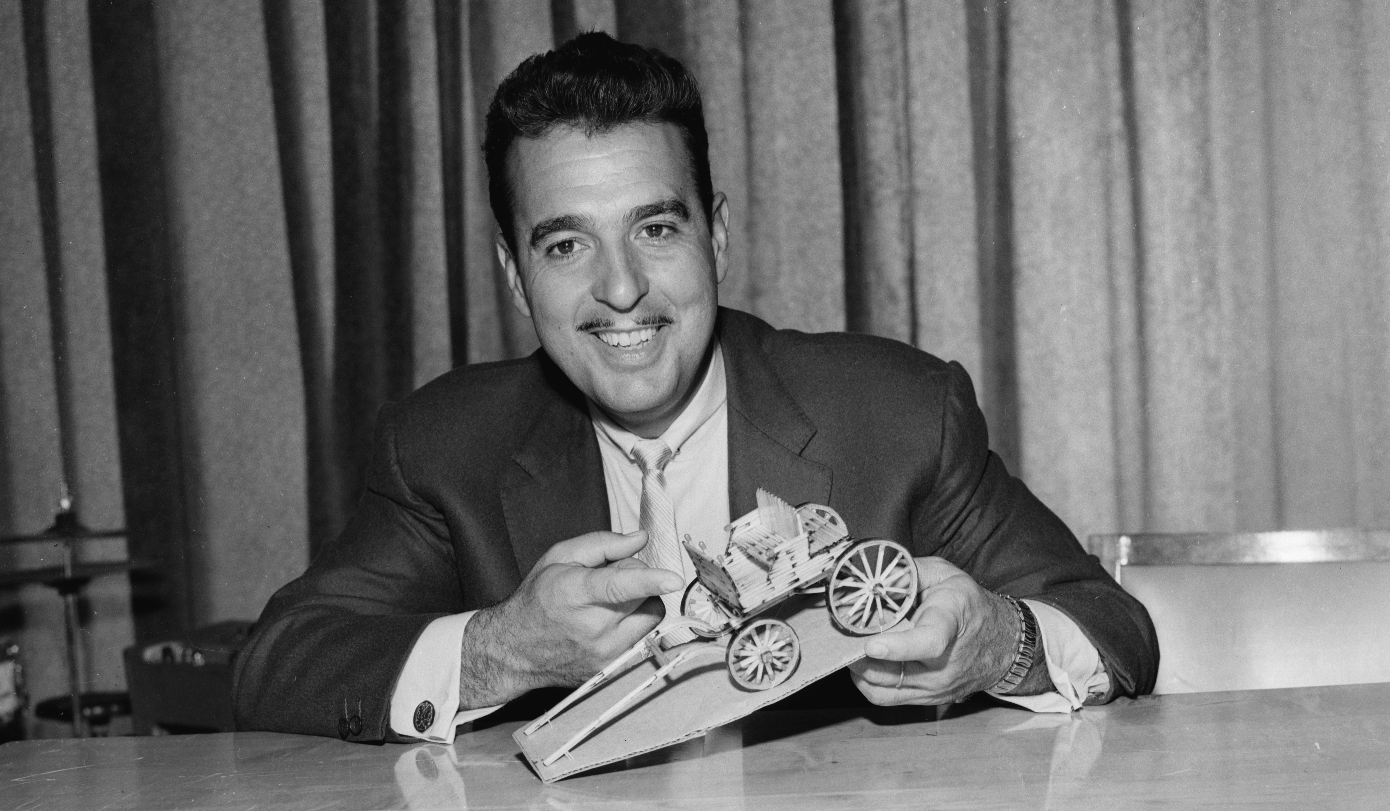 (Original Caption) Tennessee Ernie Ford proudly displays the matchstick wagon which was made by an inmate of the Marquette Prison especially for Ford whose CBS-Radio program is a favorite at the penal institution. The inmate claims he spent six months working on the project, using nothing but matches.