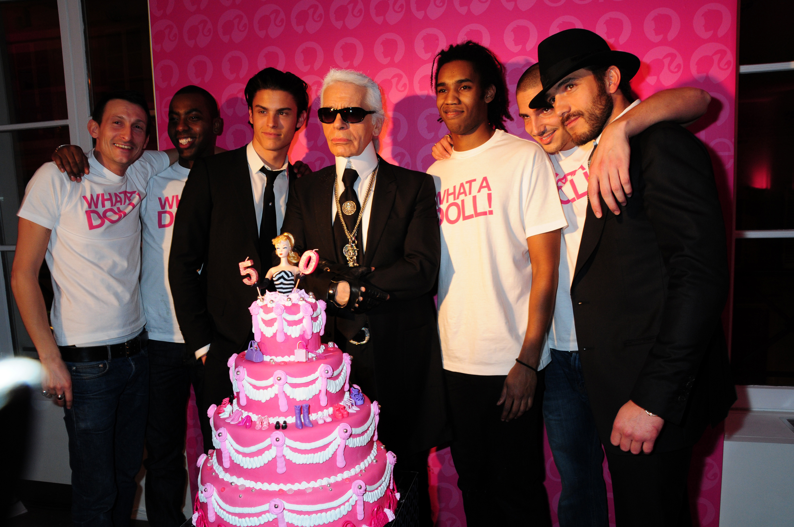 PARIS, FRANCE - MARCH 12: Top Model Baptiste Giabiconi ( Who posed for Karl Lagerfeld as Ken in black Tie ) , Fashion Designer Karl Lagerfeld, his Secretary Model Sebastien Jondeau ( Hat ) and Waiters in White Tee-Shirts attend the Barbie 50th Anniversary: Karl Lagerfeld Exhibition Preview Cocktail at Colette's Shop Gallery on March 12, 2009 in Paris, France. 