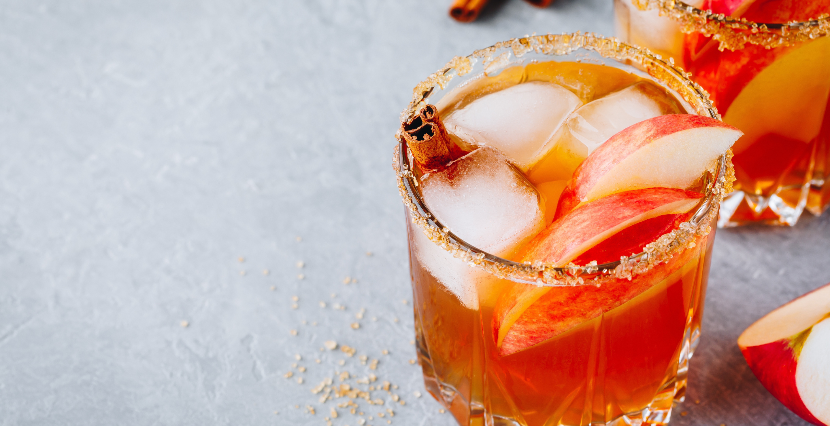 Chai spiced Apple cider cocktail for Halloween or Thanksgiving in glass on gray stone background