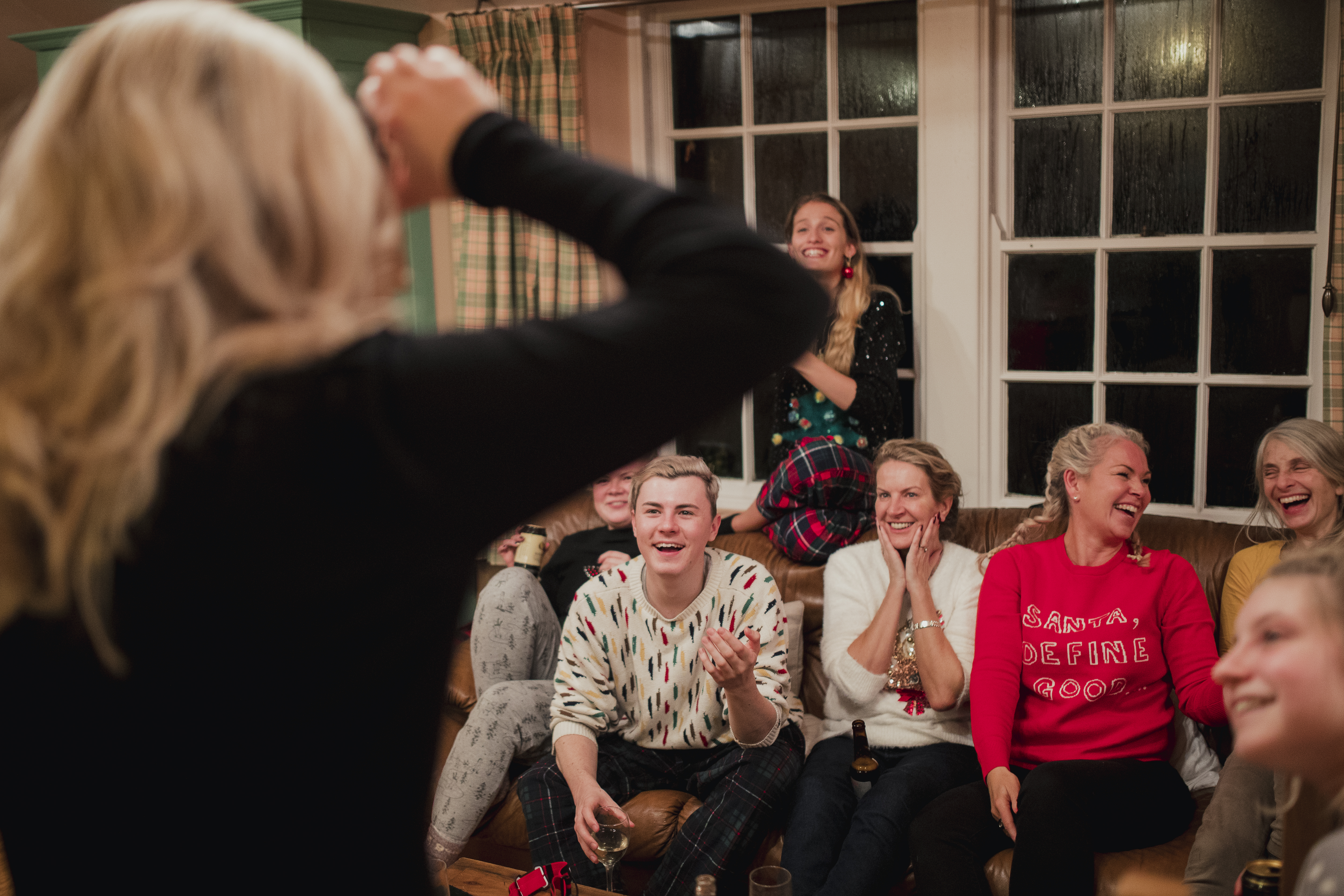 Group of friends and family are playing a modern guessing game with a smartphone at christmas.