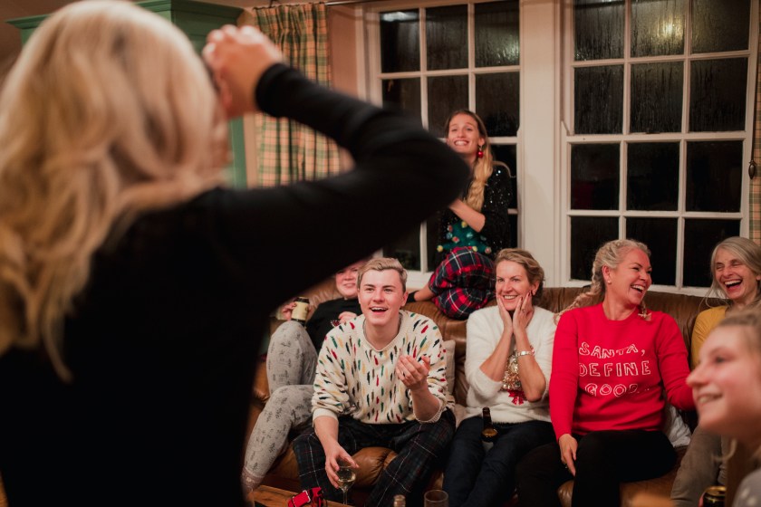 Group of friends and family are playing a modern guessing game with a smartphone at christmas.