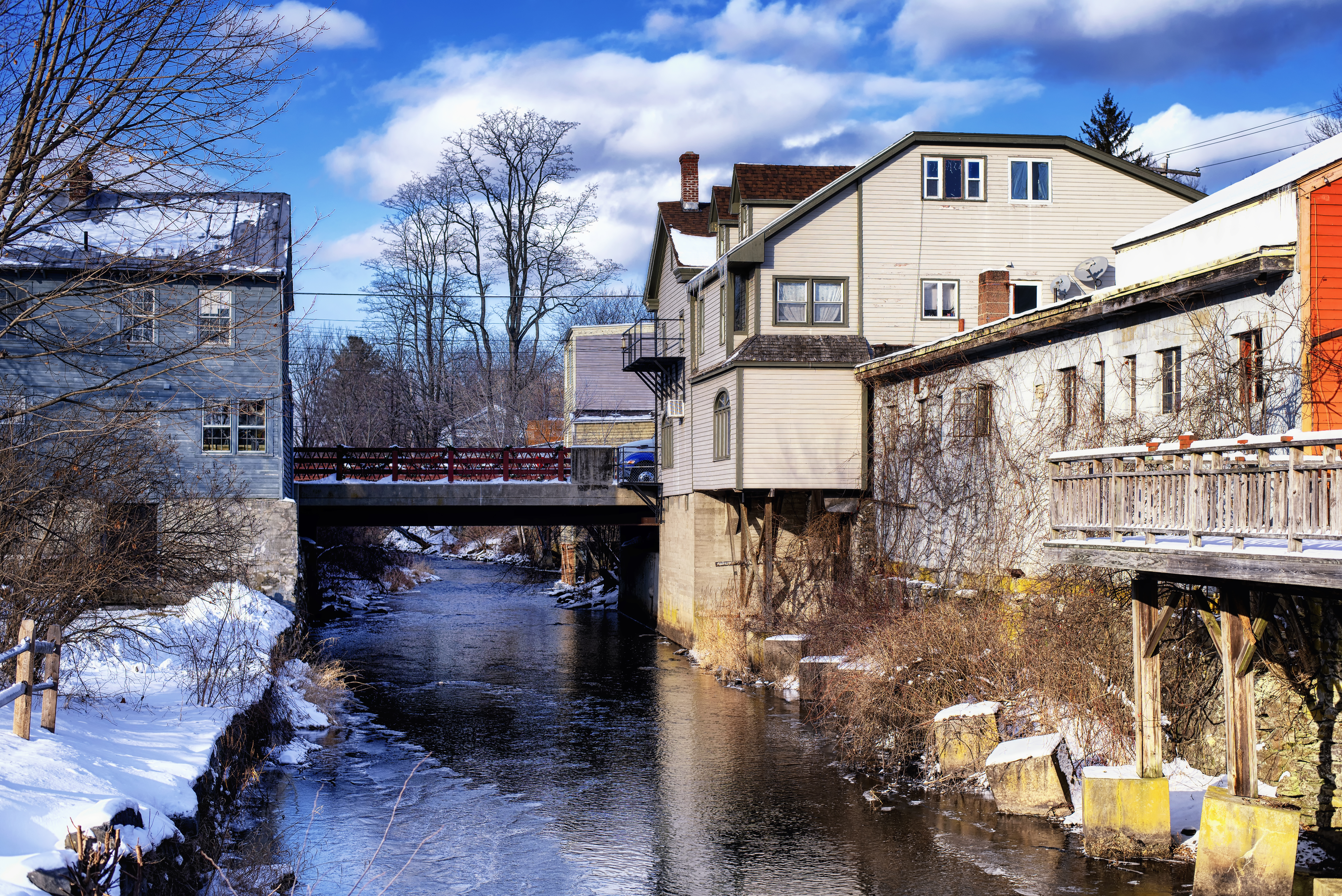 Old buildings lining the williams river running through the village of west stockbridge massachusetts on a sunny winter day.