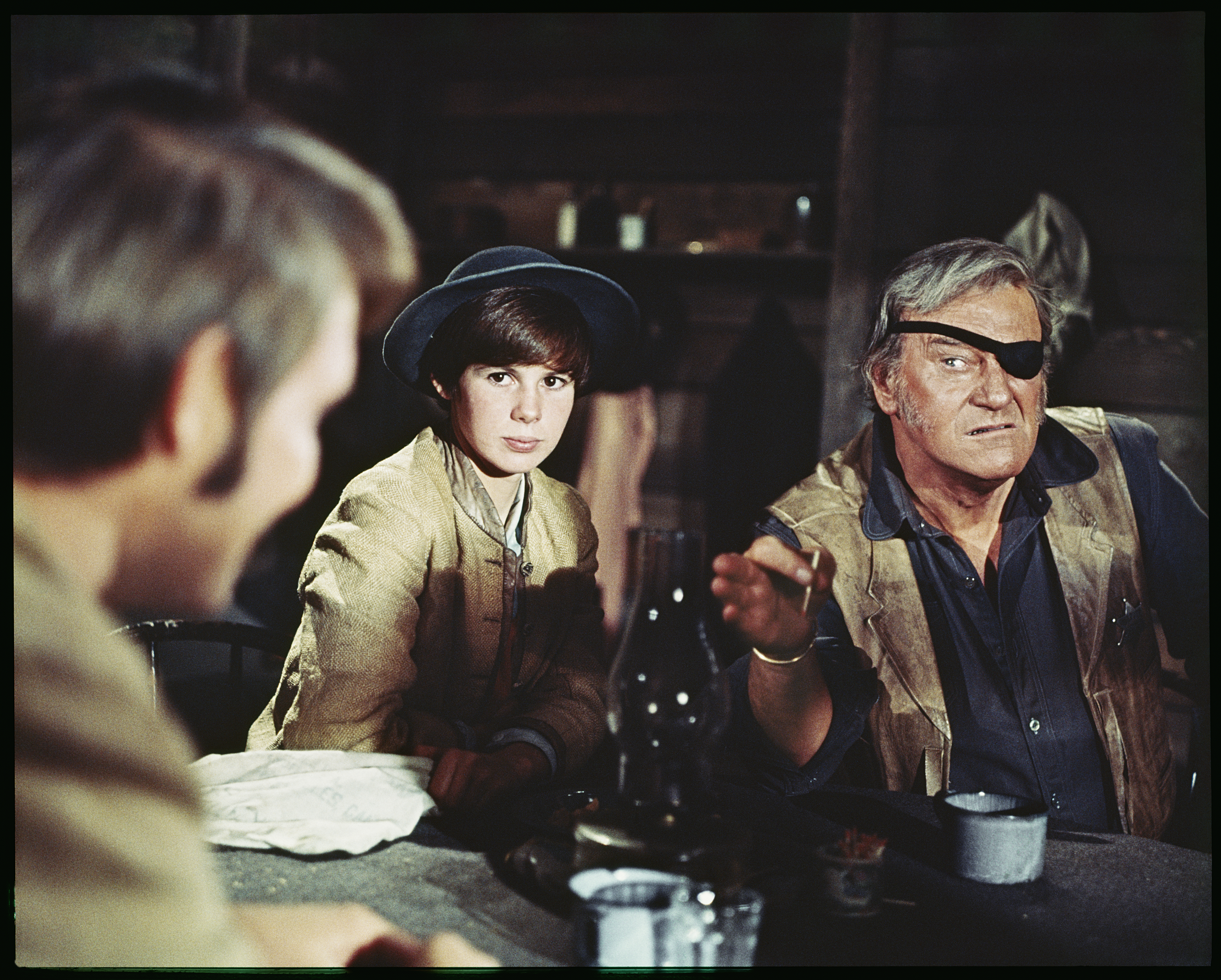 UNITED STATES - CIRCA 1969: John Wayne points ominously at Glen Campbell, while sitting next to the actress Kim Darby in this scene from the western "True Grit", 1969.