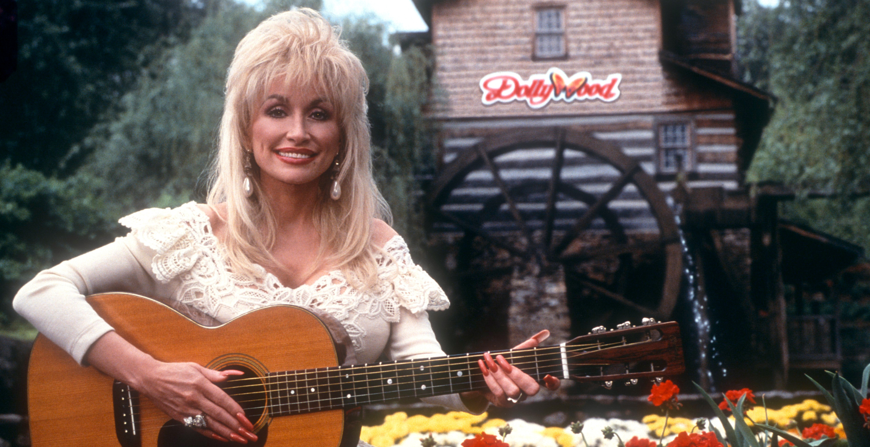 American singer and songwriter Dolly Parton poses for a portrait with her guitar at Dollywood circa 1993 in Pigeon Forge, Tennessee.