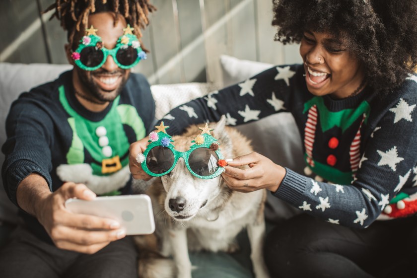 Couple and dog taking Christmas photos